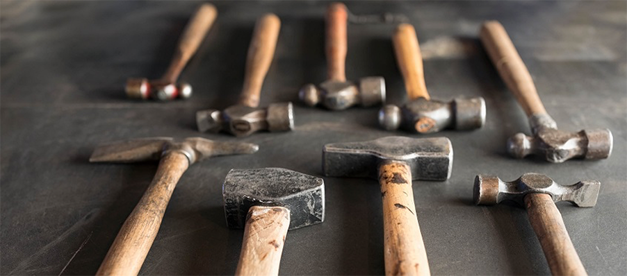 Photo of hammers arranged on a workbench.
